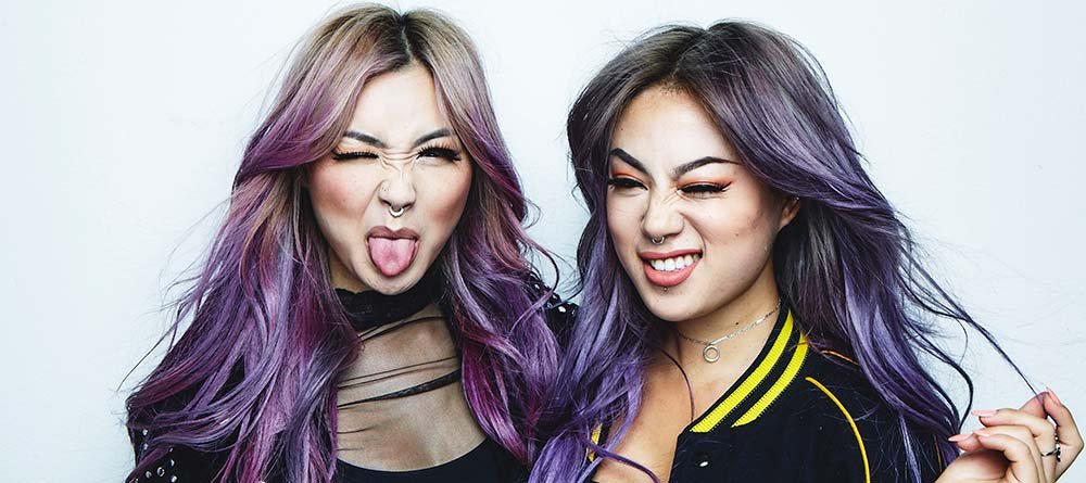 Dos modelos posan graciosas con uno de los colores del Orgullo en su pelo