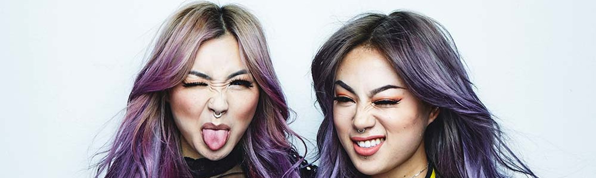 Dos modelos posan graciosas con uno de los colores del Orgullo en su pelo