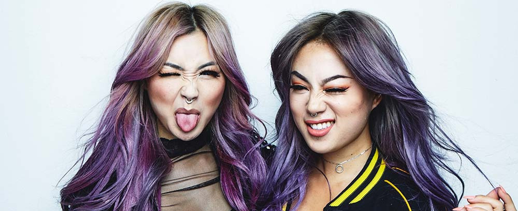 Dos modelos posan graciosas con uno de los colores del Orgullo en su pelo