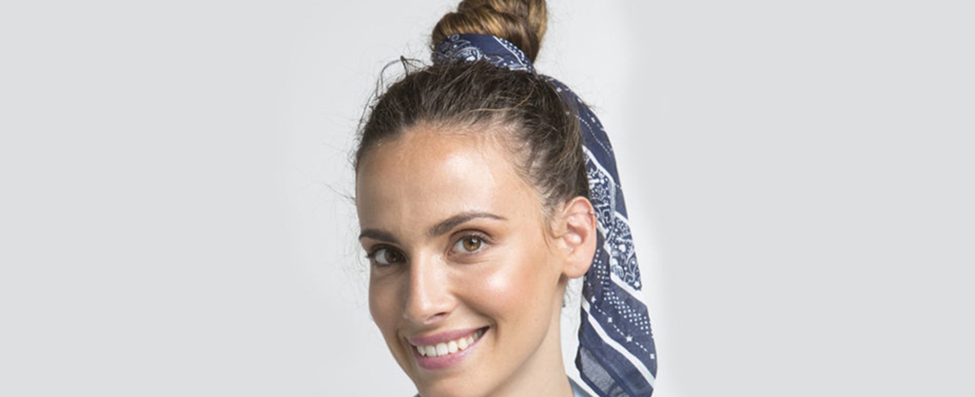 Con un pañuelo boho chic la modelo adorna su moño alto. El resultado: sexy y favorecedor