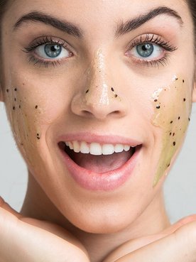 La modelo seca suavemente su cara con una toalla tras haber exfoliado su piel.